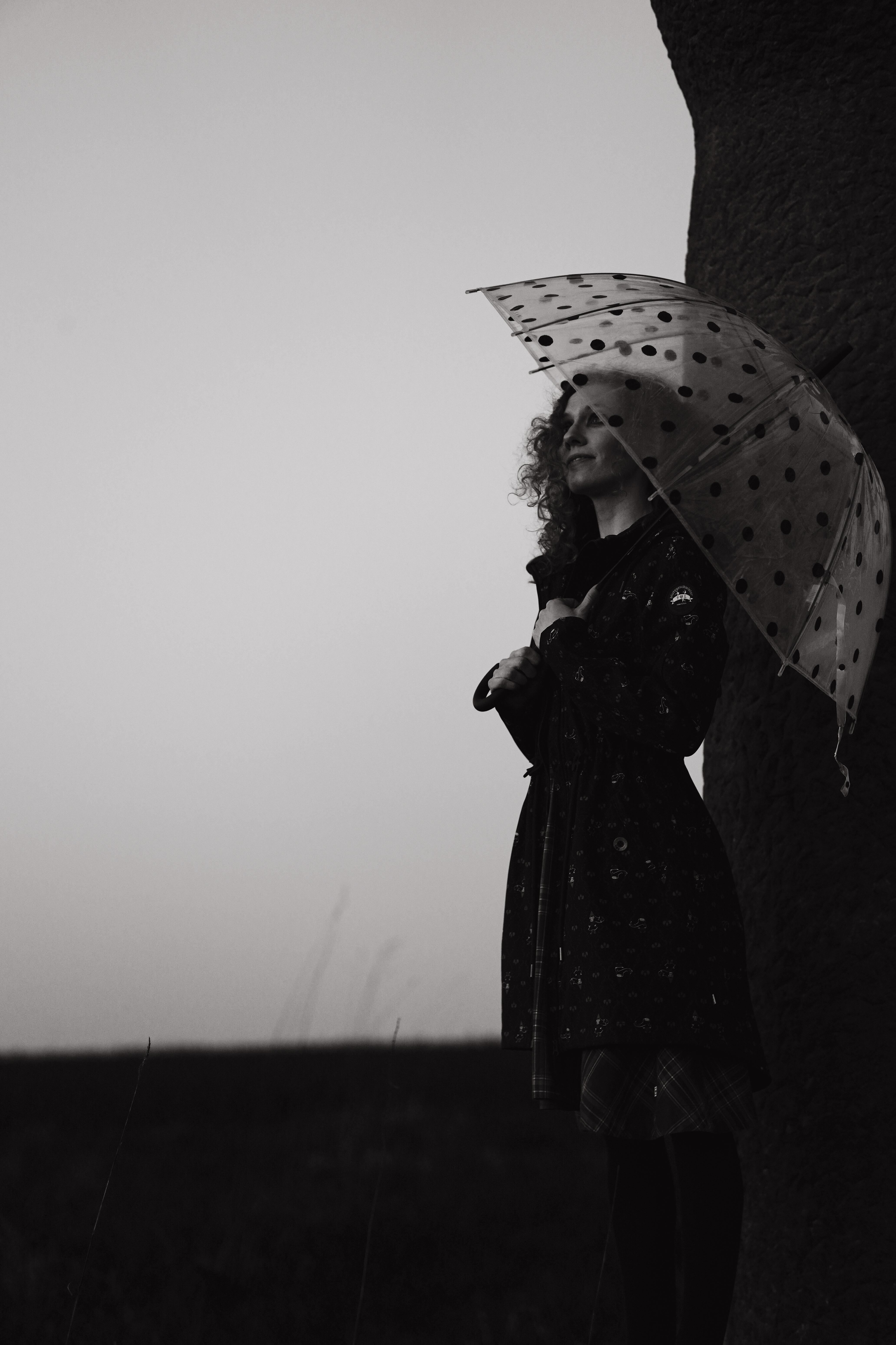 frau mit Regenschirm, steine an der grenze